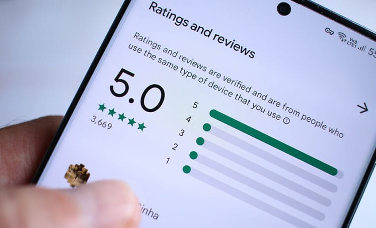 Smartphone displaying a 5.0 rating and five-star reviews